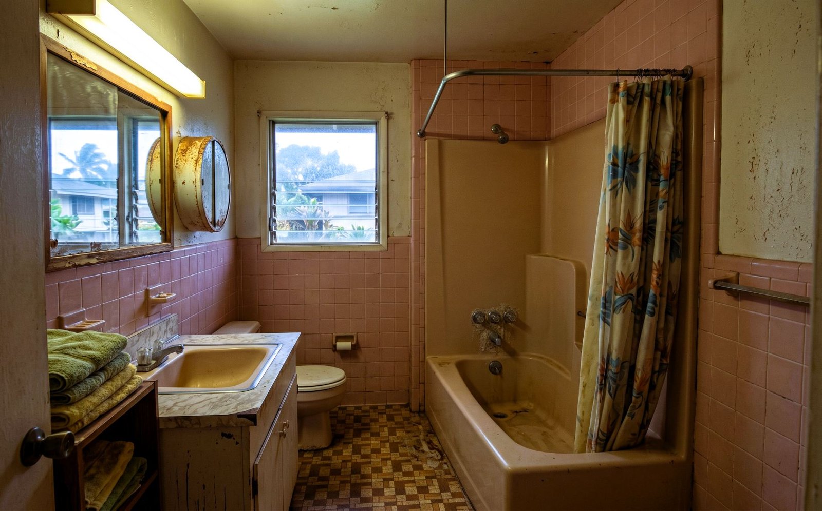 1960s pink-tile bathroom with worn tub, before