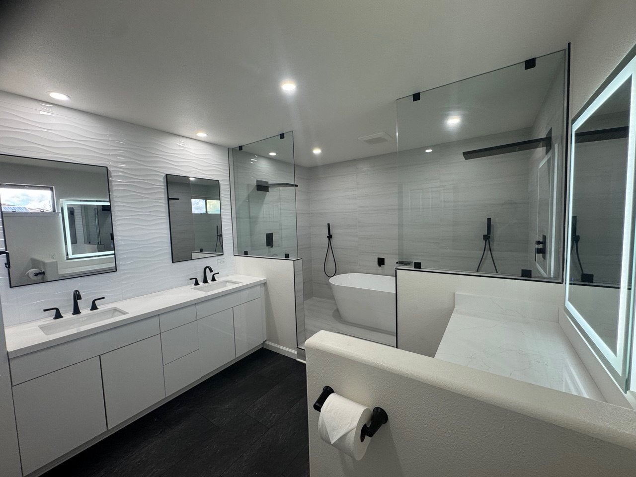 Open master bath with freestanding tub and dual walk-in showers, after